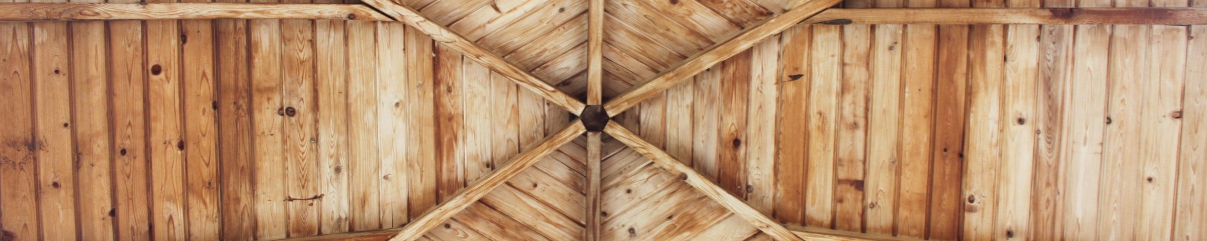 Offener Dachstuhl aus Holz von unten fotografiert